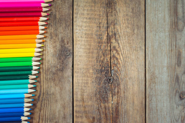 istock Colored pencils in gradient order located at the edge on wooden table. School concept. Copy space 865825614