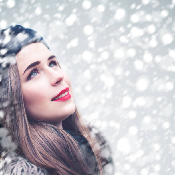 istock Beautiful Model Woman Looking Up on Snowfall Winter Background. First Snow 865826134