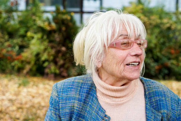 A shot of a caucasian senior female smiling and looking very happy and natural outdoors.