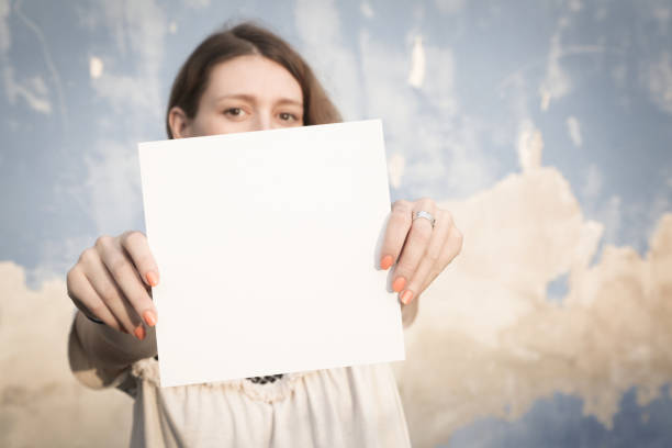 istock Woman holding white blank paper 865831946