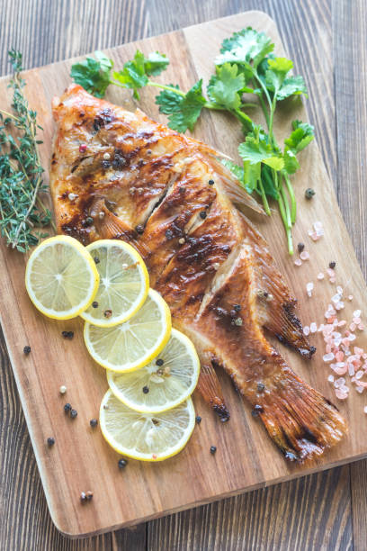 istock Grilled Tilapia with herbs on the wooden board 865832192