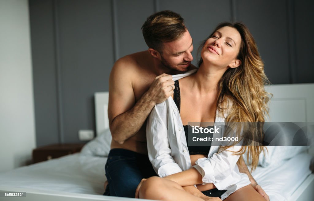 Attractive couple sharing intimate moments in bedroom Attractive young couple sharing intimate moments in bedroom Sexual Issues Stock Photo