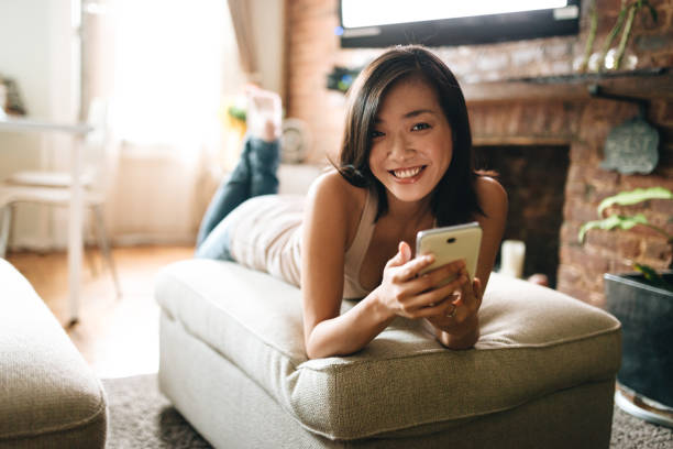 istock woman using the phone in the living room 865833400