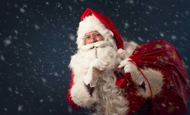 istock Santa Claus making a silence gesture, on dark background 865835934