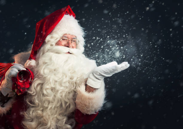 Santa Claus blowing magic snow of his hands stock photo