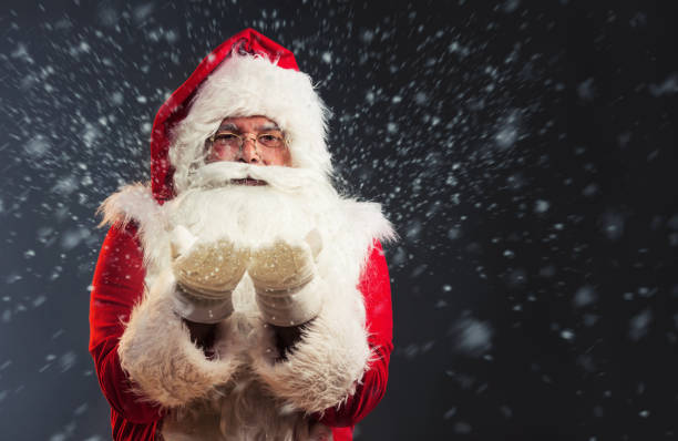 istock Santa Claus blowing snow of his hands 865836476