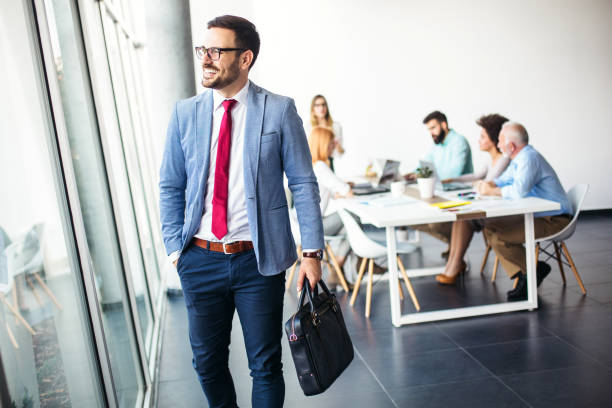 Young businessman going home from work Handsome young businessman walking away from work and going home from modern office office leave stock pictures, royalty-free photos & images