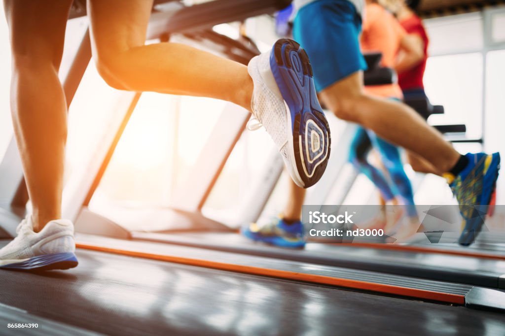 Picture of people running on treadmill in gym Picture of people doing cardio training on treadmill in gym Leg Stock Photo