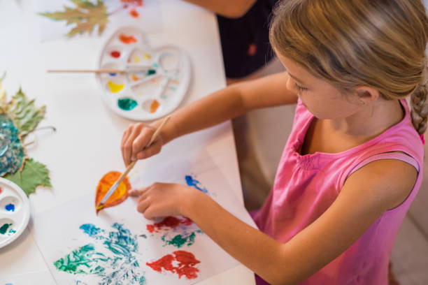 istock Cute girl painting leaf 865864594