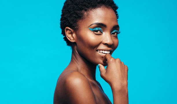 istock Woman with makeup smiling against blue background 865867386