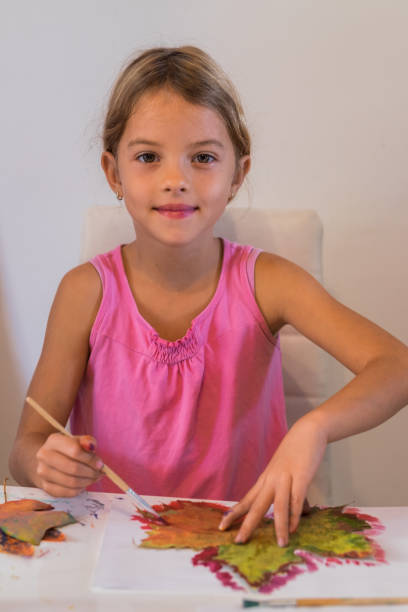 istock Cute little girl painting leaf 865867932