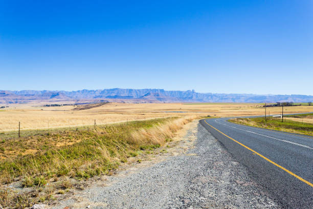 Perspective road view from South Africa along the road to Dragon's mountains. Drakensberg landscape. Travel and outdoor