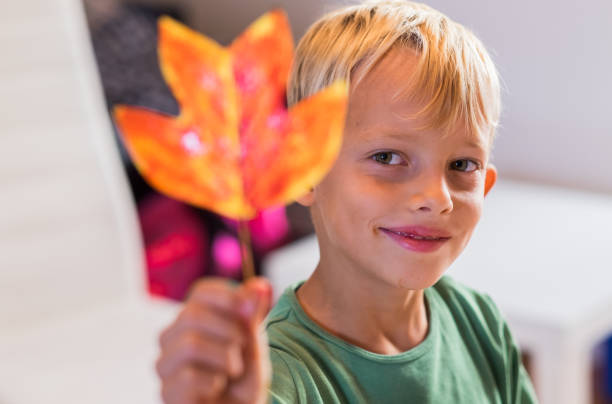 istock Beauty little boy holding orange colored leaf 865868040