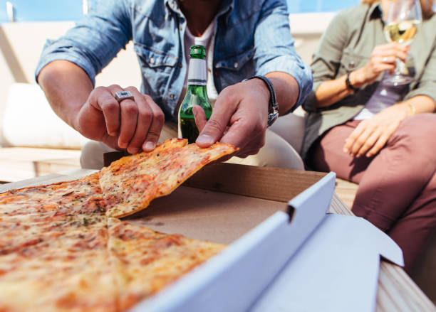 istock Friends eating pizza on rooftop party 865871834