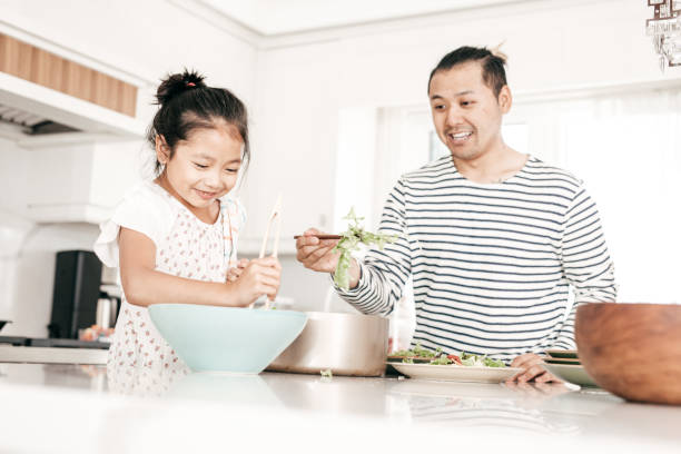 istock Dad and daughter preparing dinner together 865872078