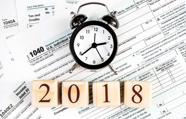 istock Clock with numbers 2018 on the tax forms. Close up. Financial concept. 865884002