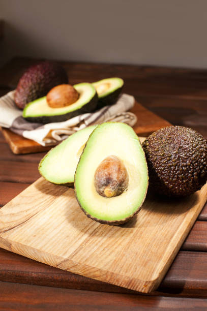 istock Sliced ripe avocado on wooden cutting board. 865889972