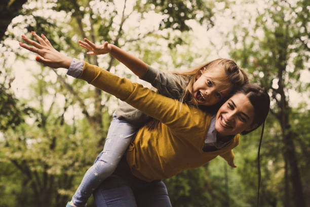 istock Mother giving her daughter piggyback ride. 865899504