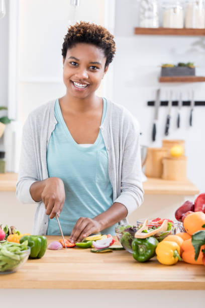 istock Cheerful woman chops vegetables on kitchen counter 865900166
