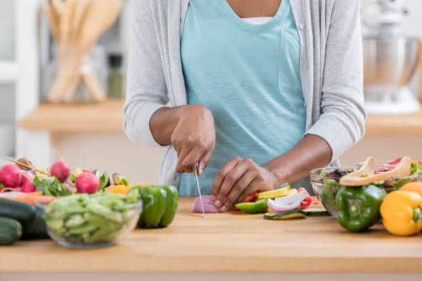 istock Unrecognizable woman chops produce on kitchen counter 865900172