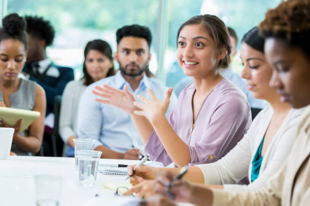 istock Woman gestures while participating in panel discussion during business seminar 865902978