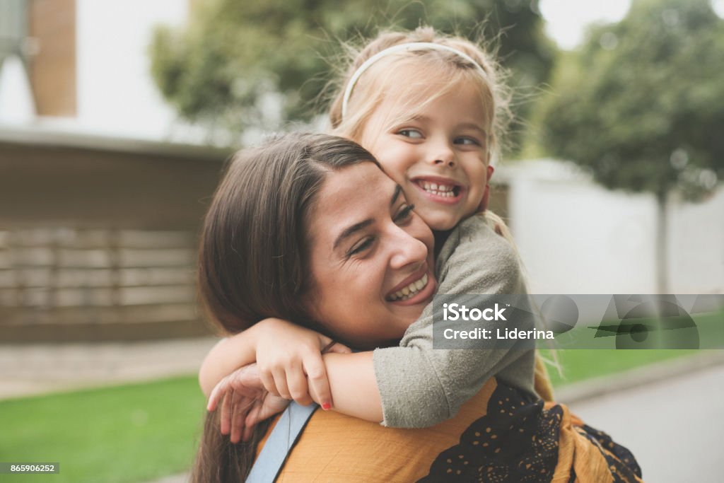 Little girl in Moms hug. One Parent Stock Photo