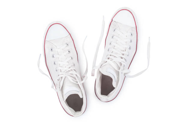 Classic white sneakers with untied the laces isolated on white background top view