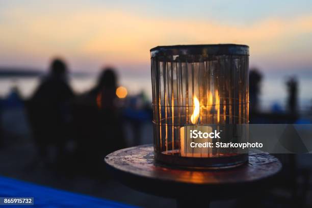 Romantisches Abendessen In Einem Café Am Meer Bei Sonnenuntergang Eine Kerze Brennt Auf Dem Tisch Für Die Gäste In Einem Café Stockfoto und mehr Bilder von Im Freien