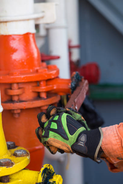 istock Man or able seaman is opening valve of a big pipe. Liquid Cargo 865923506