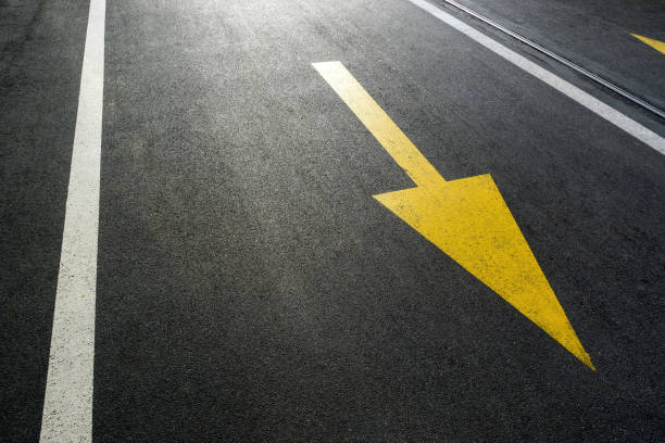 Yellow arrow on an empty asphalt road.