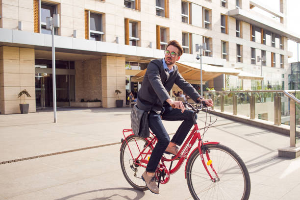 istock handsome young businessman on a bicycle 865938654