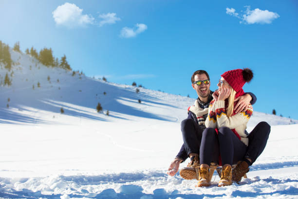istock Young Couple Sledding And Enjoying On Sunny Winter Day 865940234