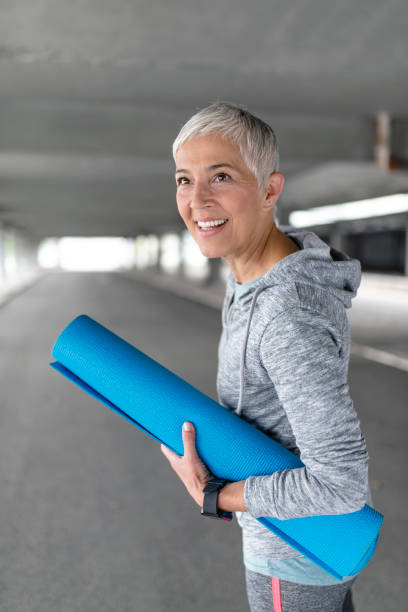 istock Woman With Rolled Up Exercise Mat 865942838