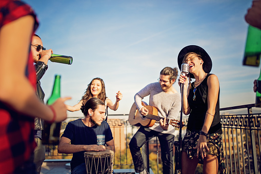 Group of friends are celebrating with a concert on the roof terrace