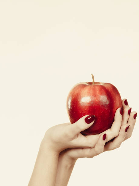 istock Woman hand holding delicious red apple 865951148