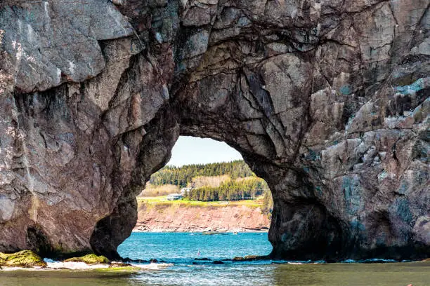 Rocher Perce rock in Gaspe Peninsula, Quebec, Gaspesie region with birds and cliffs during day
