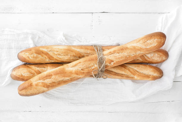 흰색 나무 테이블에 갓   구운된 프랑스 baguettes - baguette 뉴스 사진 이미지