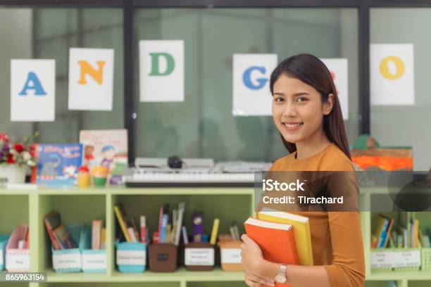 Pretty Asian Teacher Smiling At Camera At Back Of Classroom At The Elementary School Vintage Effect Style Pictures Stock Photo - Download Image Now