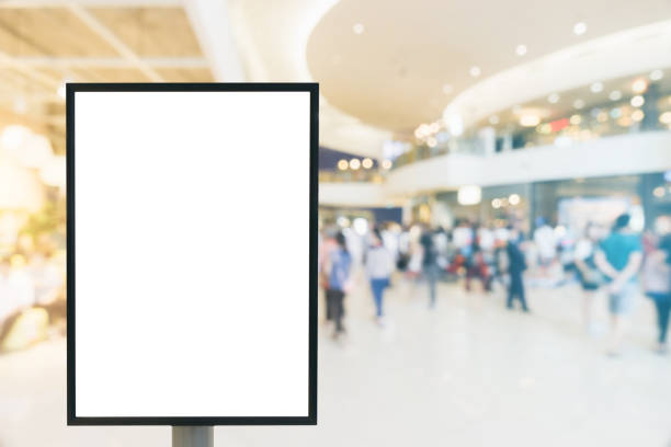 istock Blank mock up of vertical poster billboard sign with copy space for your text message or content in modern shopping mall. Blank mock up of vertical street poster billboard department store background. 865965574