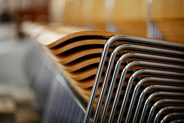 Photo of Wooden chairs with metal frame stacked neatly