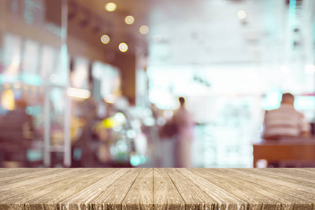 istock Empty wood plank table top with blur customer in coffee shop with bokeh light,Mock up for display or montage of product,Banner or header for advertise on social media,Food and drink background 865973096