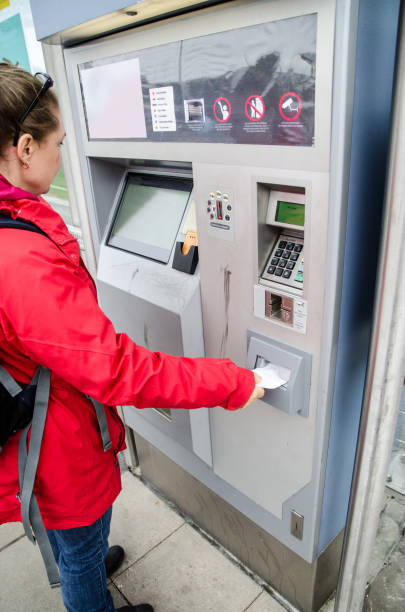 istock Woman buying a train or bus ticket at the automatic ticket machine on the exterior train station during day of autumn 865973304