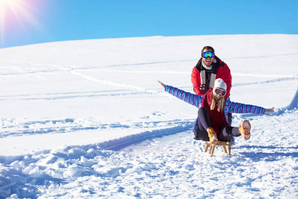 istock Young playful couple having fun sledging down snow covered hill 865976432