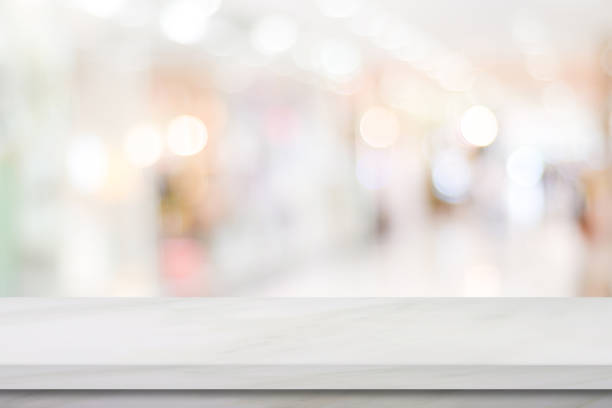istock Empty white marble table over blur store background, product display montage 865976704