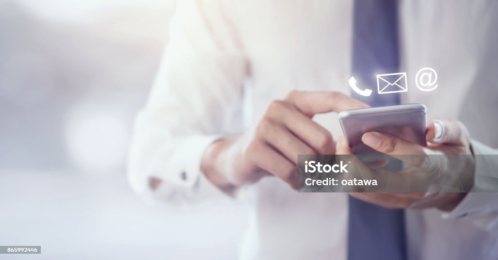 CONTACT US, Hand of Businessman holding mobile smartphone with ( mail,phone,email ) CONTACT US, Hand of Businessman holding mobile smartphone with ( mail,phone,email ) icon. cutomer support concept, copy space. Contact Us Stock Photo