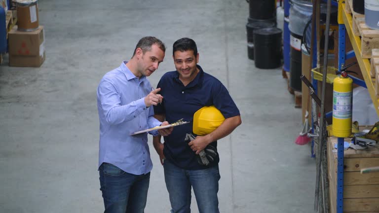 Administrator of a warehouse giving instructions to an employee of the orders to dispatch