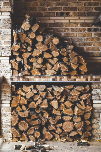 Chopped wood stacked in two levels on the porch with a brick wall