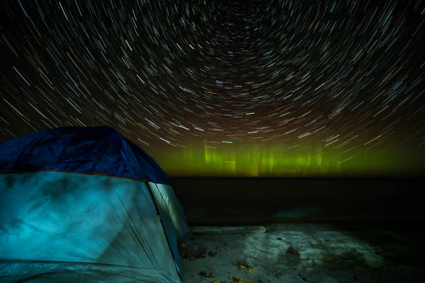 istock Star Trail Aurora Borealis Tent on Beach Shore Marquette Michigan 866009942