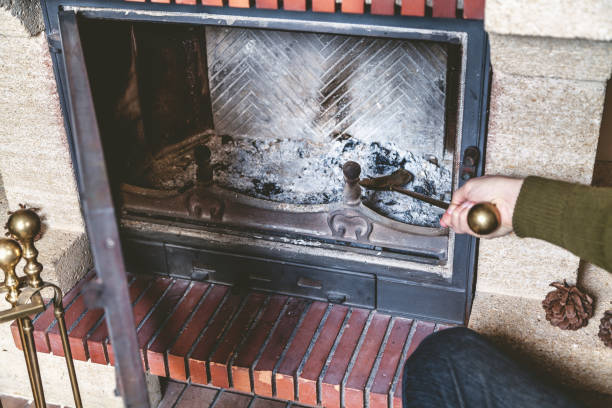 istock Cleaning  fireplace. Hand holding  shovel with ash 866018254