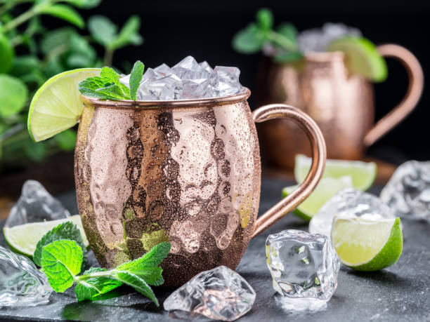 istock Moscow Mule. Frosty copper mug with lime and ice cubes on the table. 866028194
